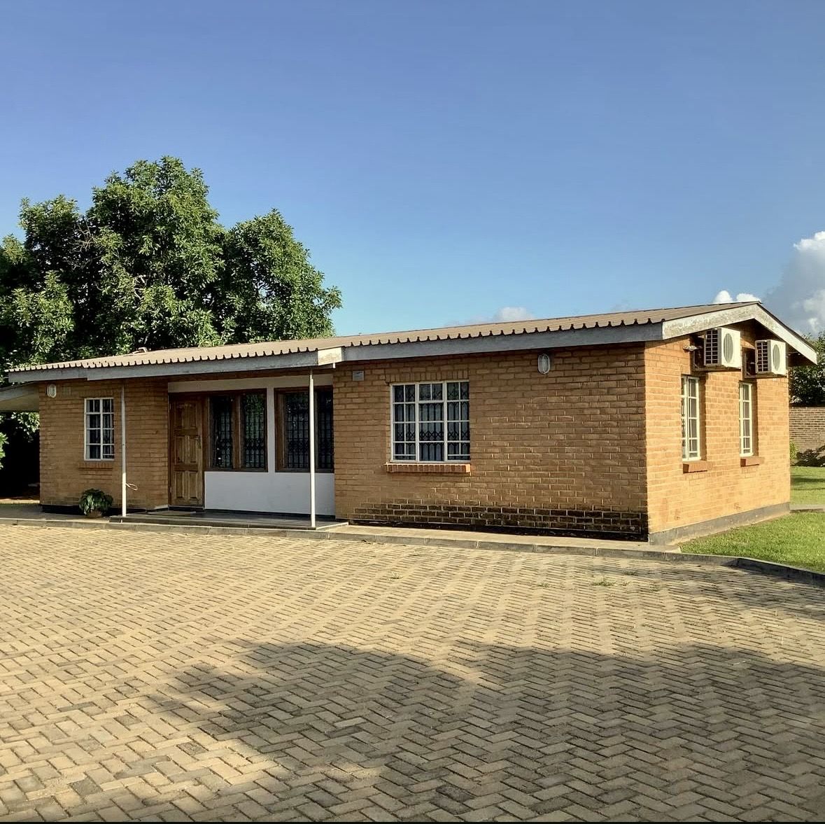 Brick building with paved herringbone courtyard